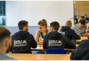 Stagiaires Prépa BPJEPS en sweat IPMS travaillant en groupe lors d'un cours théorique en salle