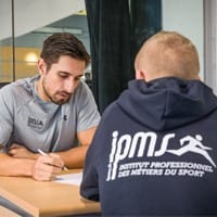 Entretien individuel entre un conseiller IPMS et un stagiaire portant le sweat officiel de l'école