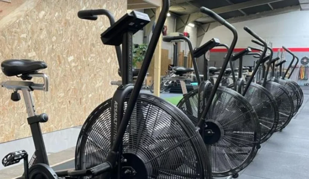 Ligne de vélos d’intérieur noirs dans la salle cardio du campus IPMS Strasbourg.