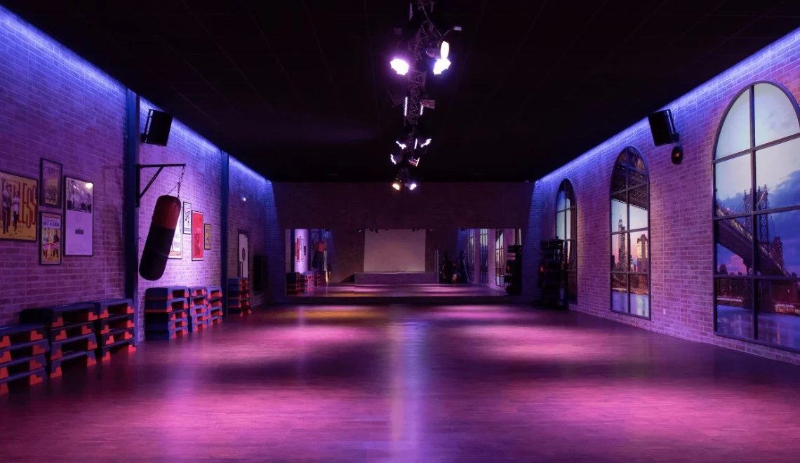 Salle de fitness IPMS Strasbourg avec décor industriel et éclairage violet.