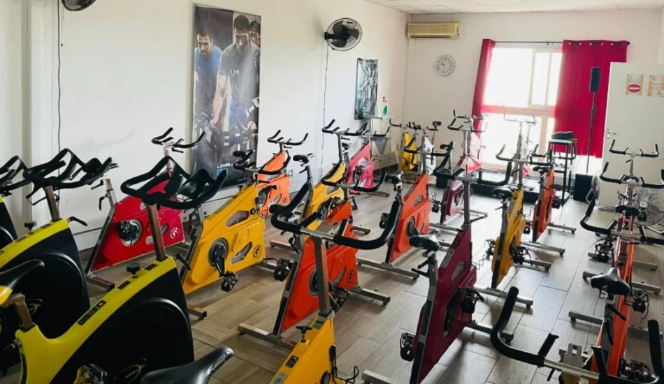 Salle de biking IPMS Saint-Louis avec vélos alignés multicolores pour les cours de cycling.