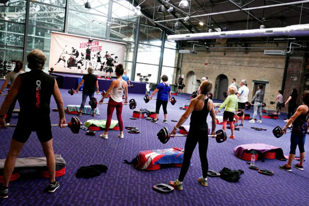 Séance BPJEPS AF à l’IPMS Le Havre : stagiaires en pratique de cours collectifs dans une grande salle lumineuse.