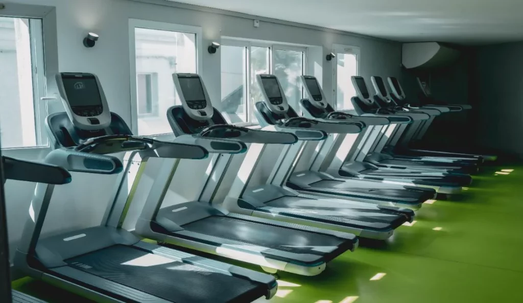 Salle cardio du campus IPMS équipée de tapis de course modernes face aux fenêtres.