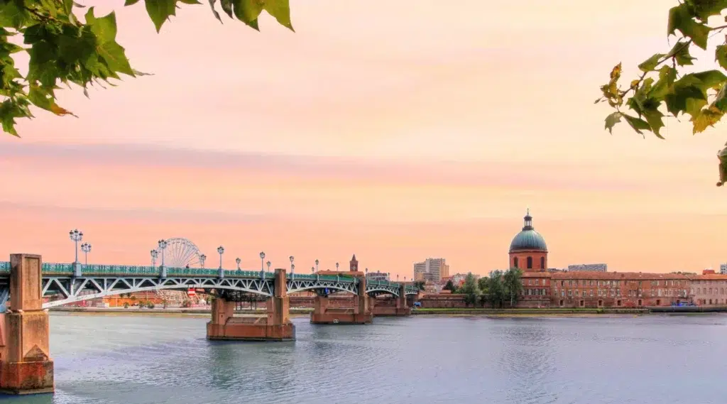 Vue du pont Saint-Pierre et du dôme de La Grave à Toulouse au coucher du soleil.