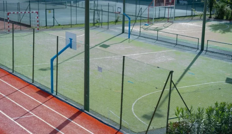 Terrain sportif IPMS avec paniers de basket et buts de handball.