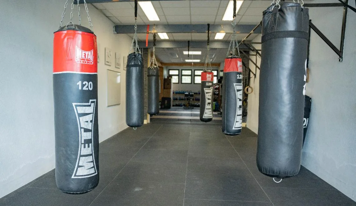 Espace de musculation IPMS avec barres, disques et structures de levage.