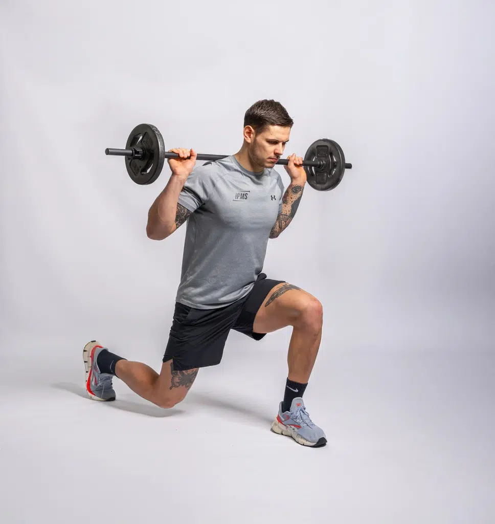 Stagiaire IPMS réalisant une fente avant avec barre chargée sur les épaules en position parfaite