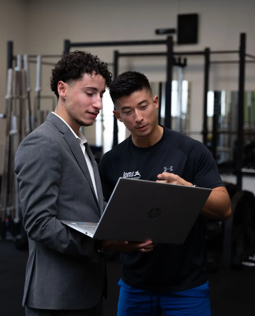 Technico-commercial en échange avec un expert autour d’un ordinateur, illustrant le conseil technique essentiel au métier.