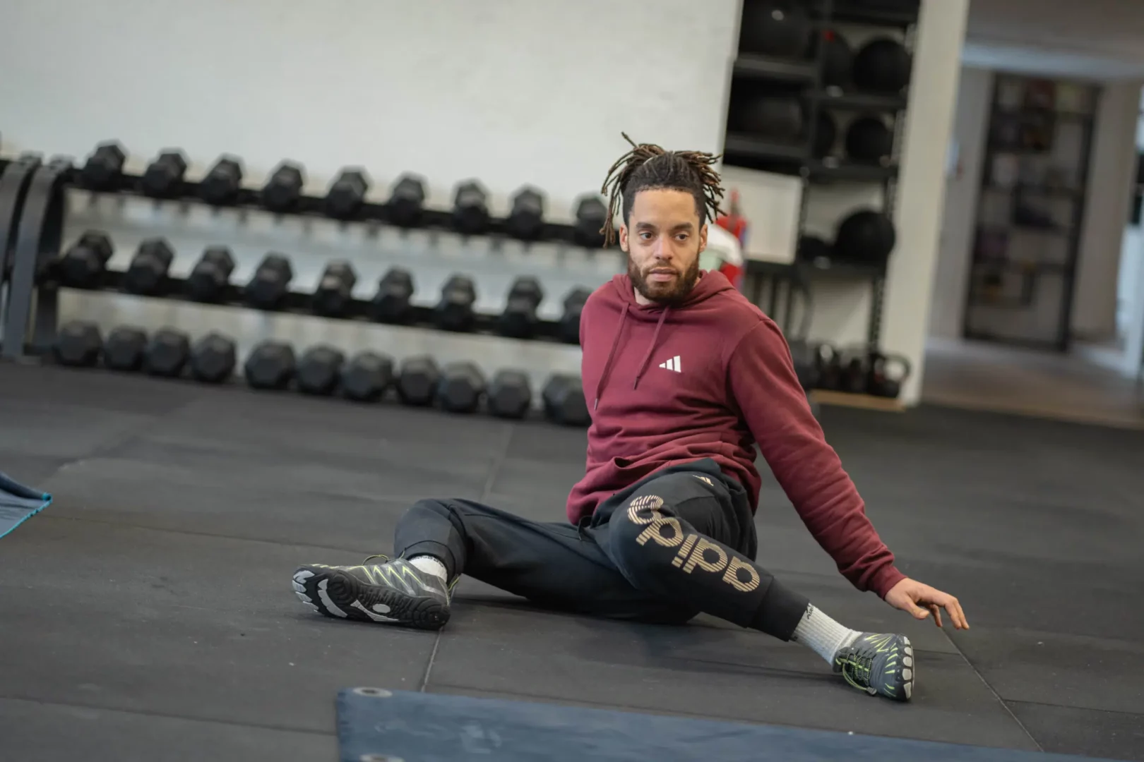 Étudiant en BPJEPS AF réalisant un étirement au sol sur le plateau musculation de l’IPMS.